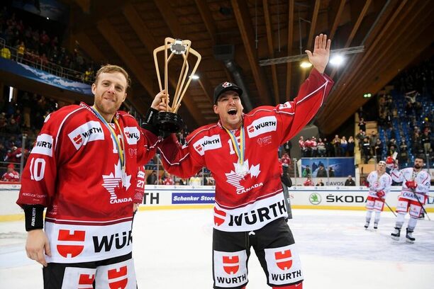 Hokejisté Kanady Kris Versteeg a Scottie Upshall se slavnou trofejí po výhře na Spengler Cupu 2023