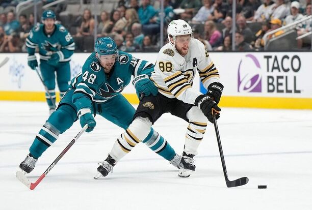 Tomáš Hertl pronásleduje Davida Pastrňáka při utkání San Jose proti Bostonu. Zahrají si na All-Star Game 2024 v jednom týmu?