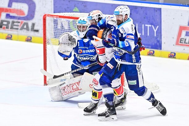 Brankář Komety Jan Kavan zasahuje proti pardubické střele. V předbrankovém prostoru Jan Ščotka (Kometa) a Lukáš Sedlák (Pardubice)