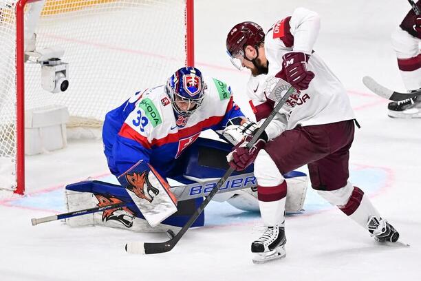 Brankář Stanislav Škorvánek a útočník Rihards Bukarts v utkání Slovensko vs. Lotyšsko na MS v hokeji 2023