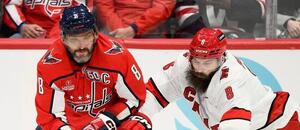 Kapitán Washingtonu Alexander Ovechkin a Brent Burns, obránce ve službách Caroliny, bojují o puk