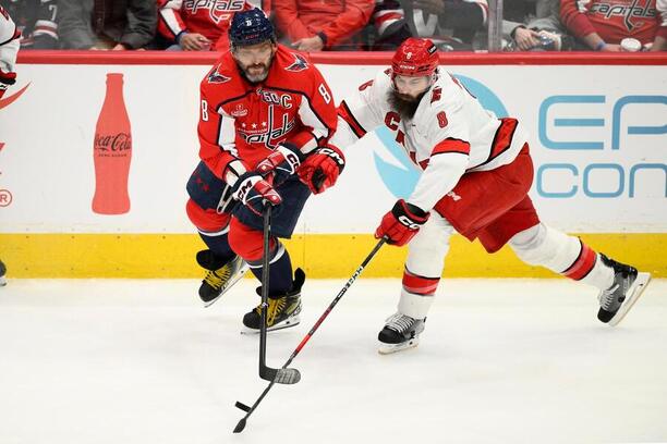 Kapitán Washingtonu Alexander Ovechkin a Brent Burns, obránce ve službách Caroliny, bojují o puk
