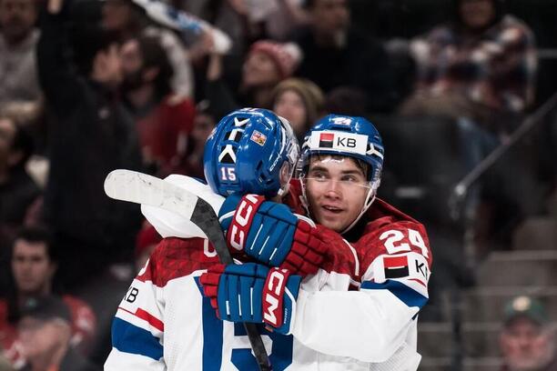 Adam Novotný (vpravo) objímá Vojtěcha Čihaře, fotka ze semifinále Česko vs. Kanada na MSJ v hokeji 2026