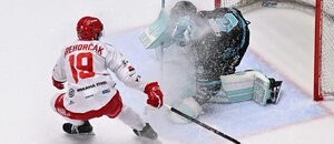 Karlovarský gólman Dominik Frodl kryje kotouč, vedle něj dotírající Patrik Hrehorčák