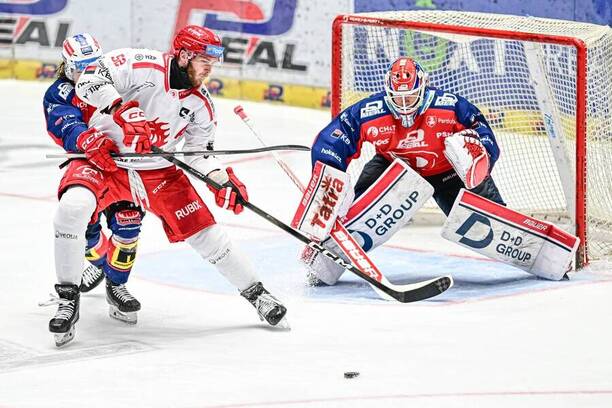 Třinecký Martin Marinčin před pardubickým brankářem Romanem Willem